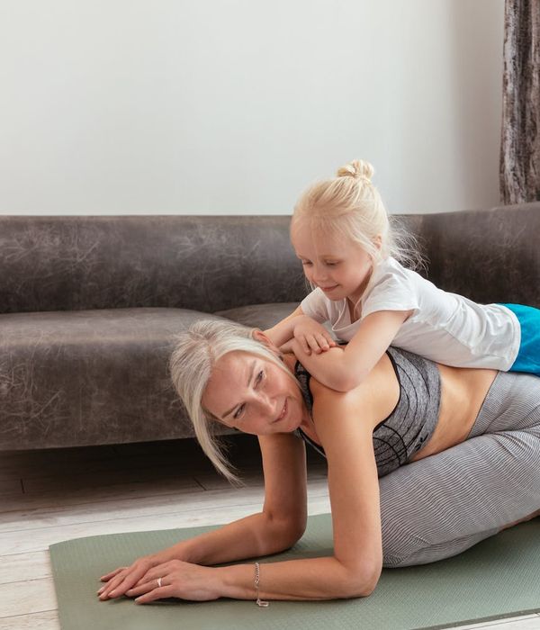 Person doing a stretching yoga pose on a mat with golden accents.